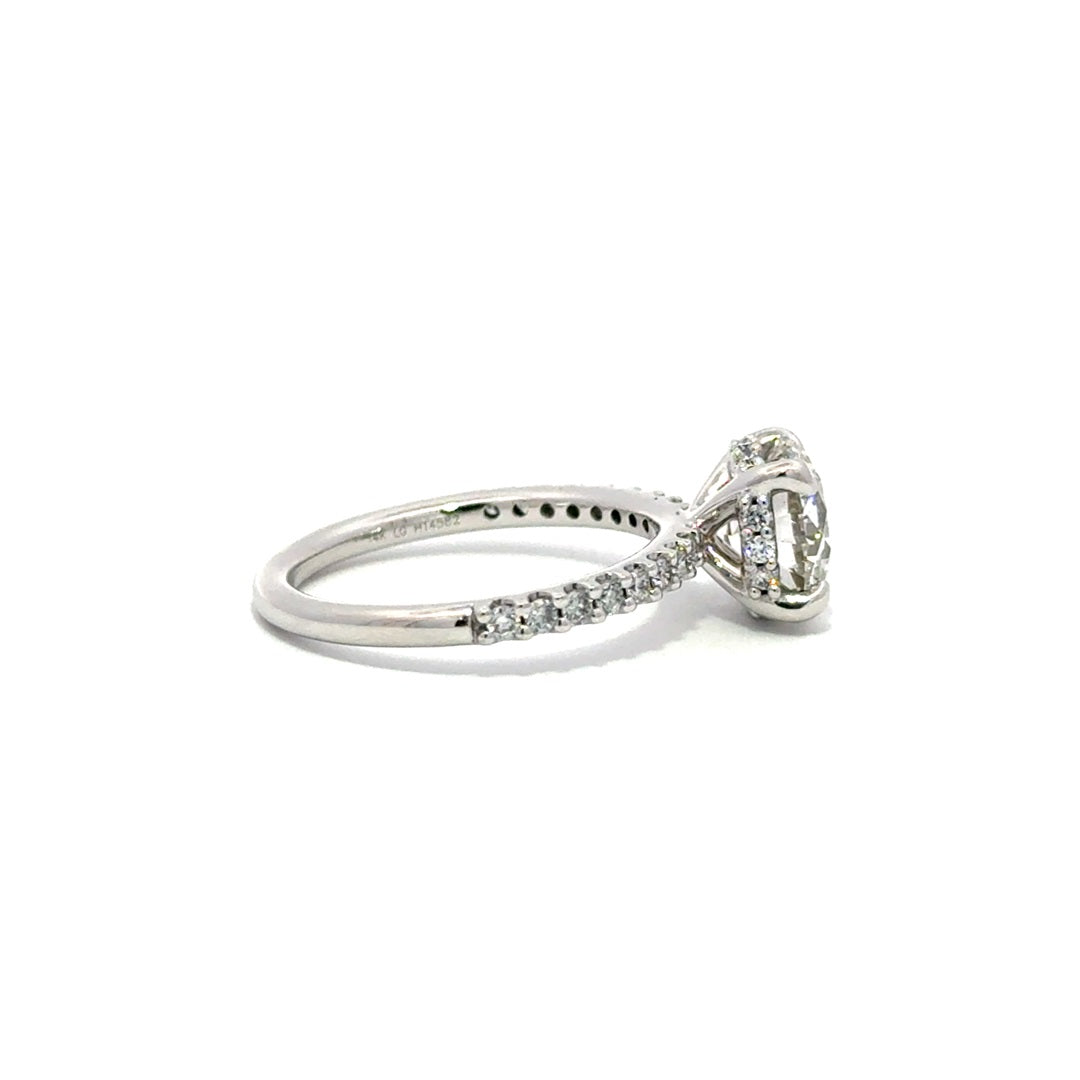 Side view of silver engagement ring with a center round cut diamond.