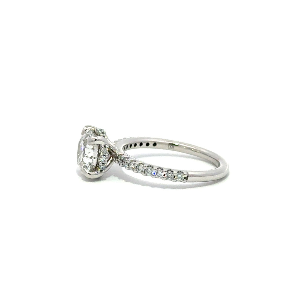 Side view of silver engagement ring with a center round cut diamond.