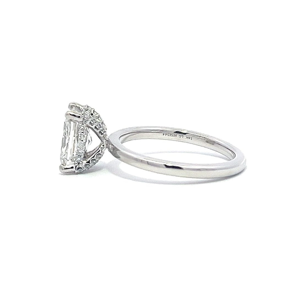 White gold engagement ring with a radiant-cut diamond center stone on a white background.