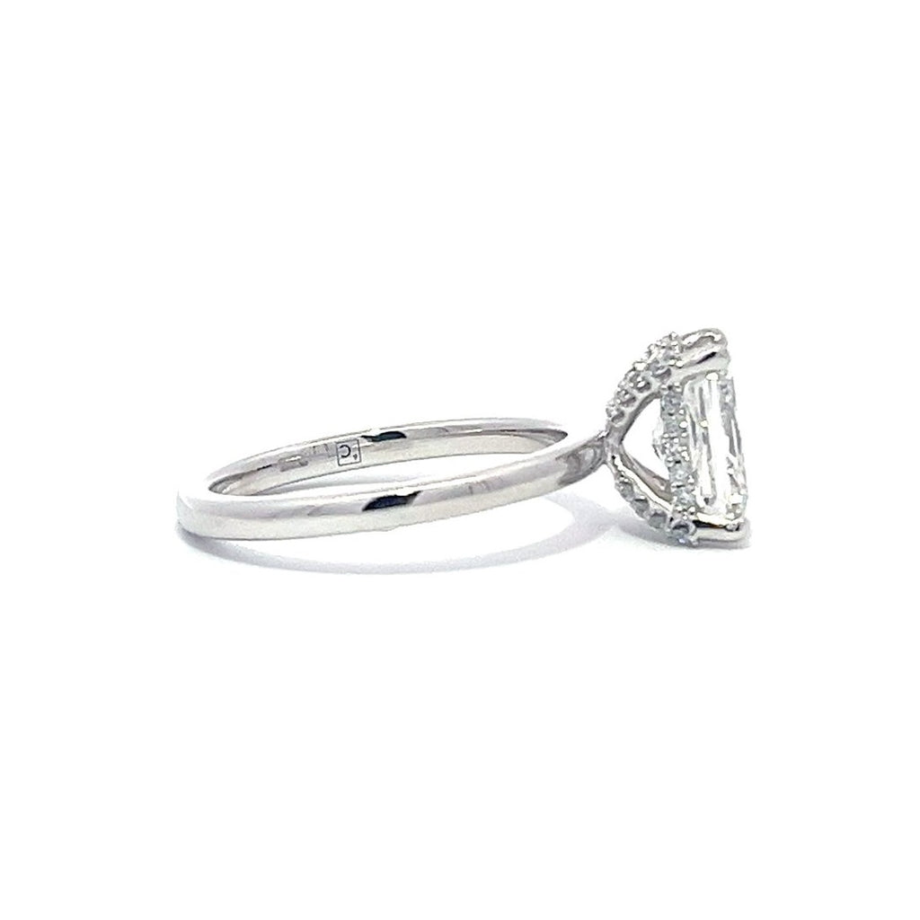 White gold engagement ring with a radiant-cut diamond center stone on a white background.