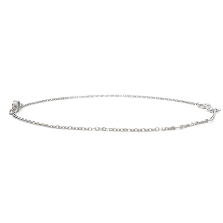 Silver bracelet with a single diamond pendant on a white background.