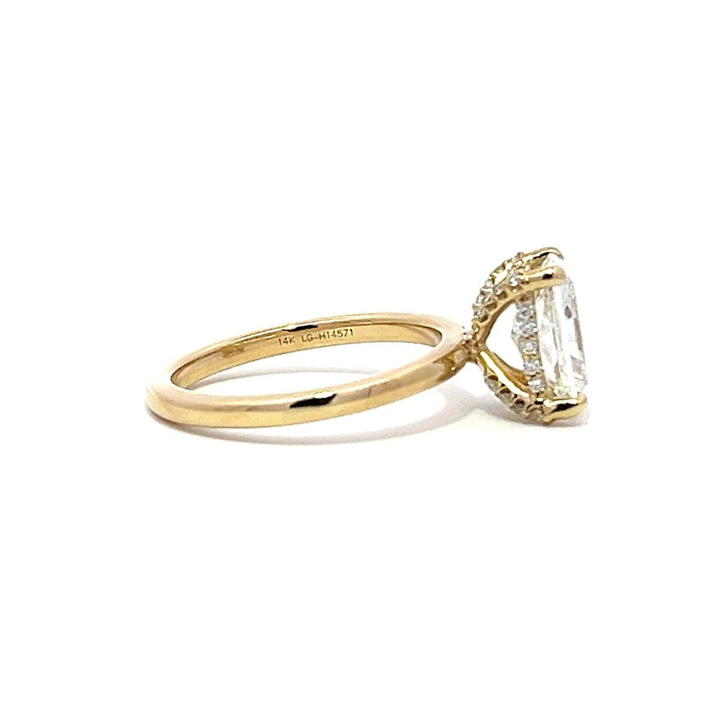 Yellow gold engagement ring with a radiant-cut diamond center stone on a white background.