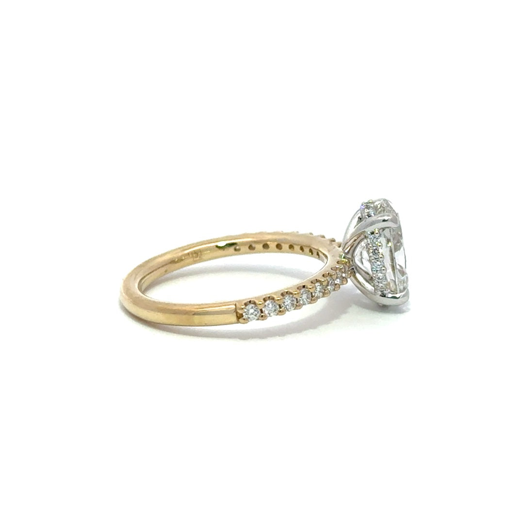 Side view of multi color yellow and white gold engagement ring with a center oval cut diamond.