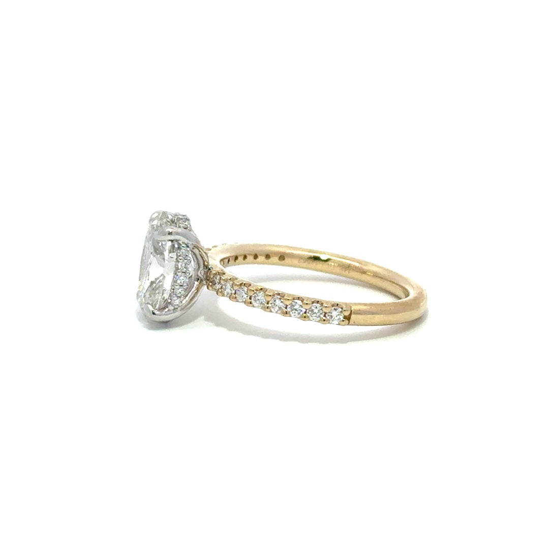 Side view of multi color yellow and white gold engagement ring with a center oval cut diamond.