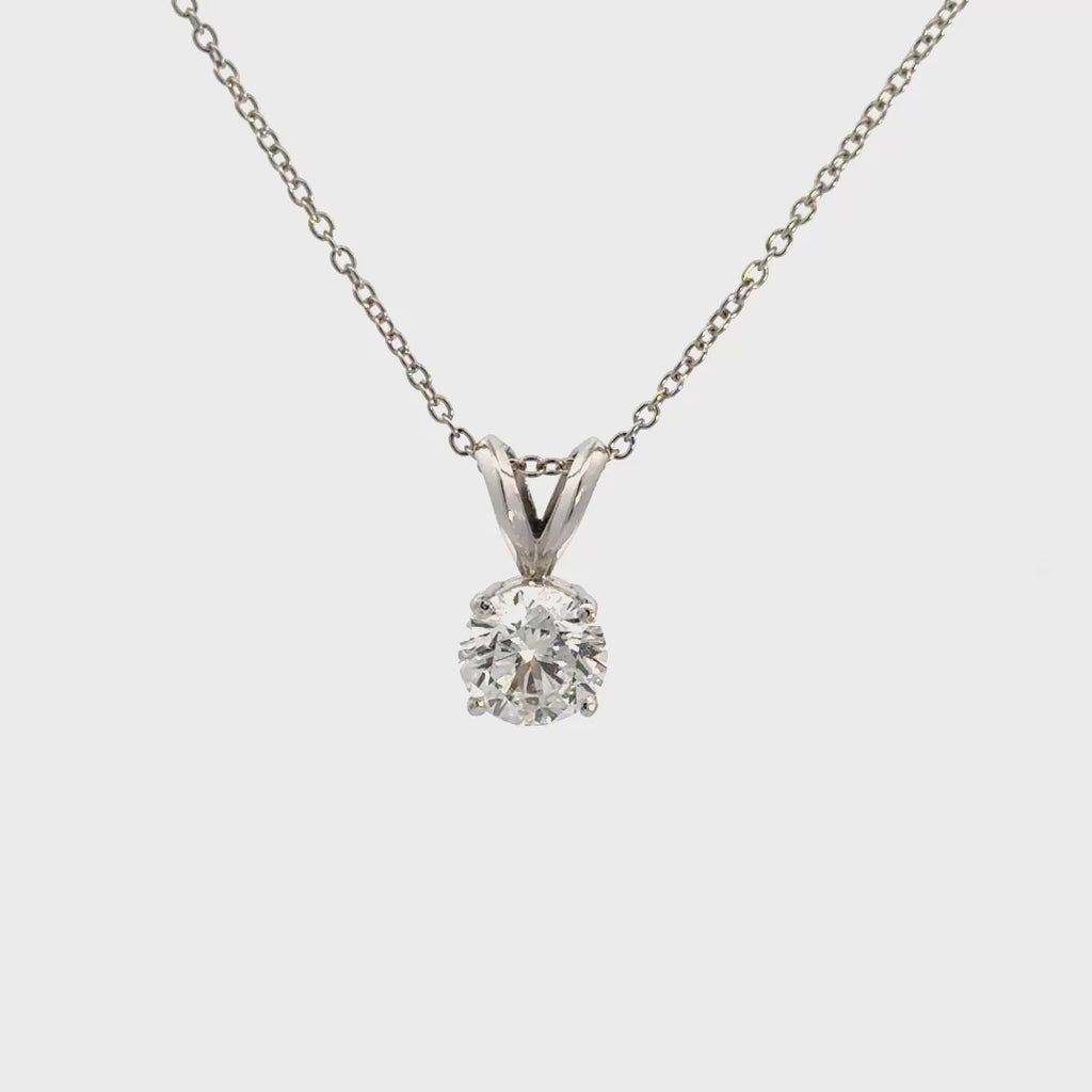 Silver necklace with diamond pendant against white background