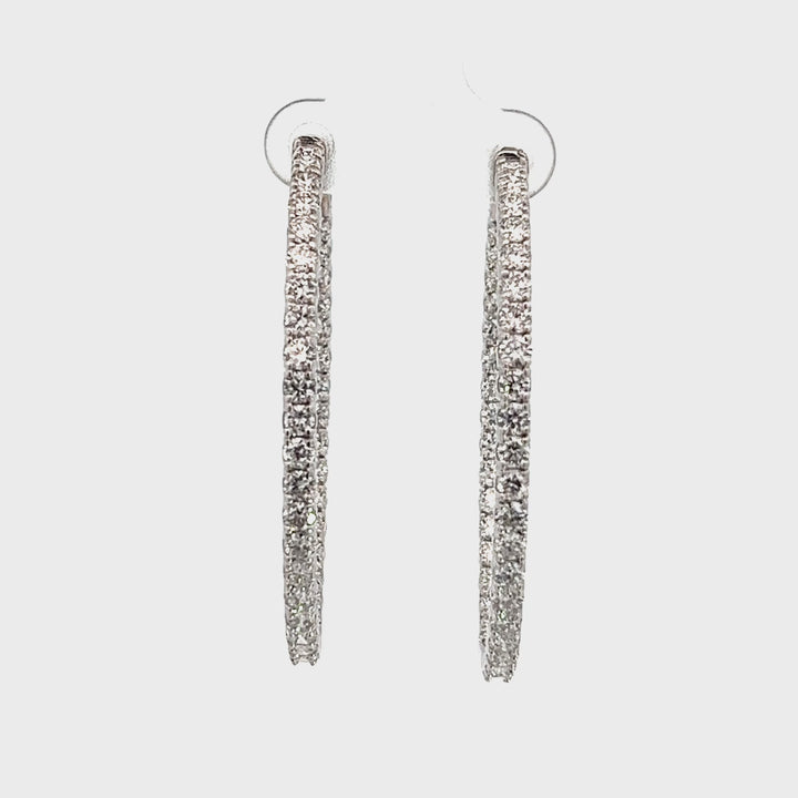 White gold diamond hoop earrings on a white background.