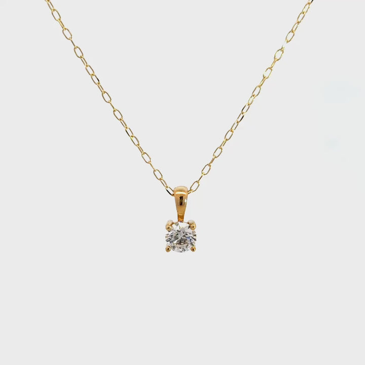 Yellow gold diamond solitaire necklace on a white background.