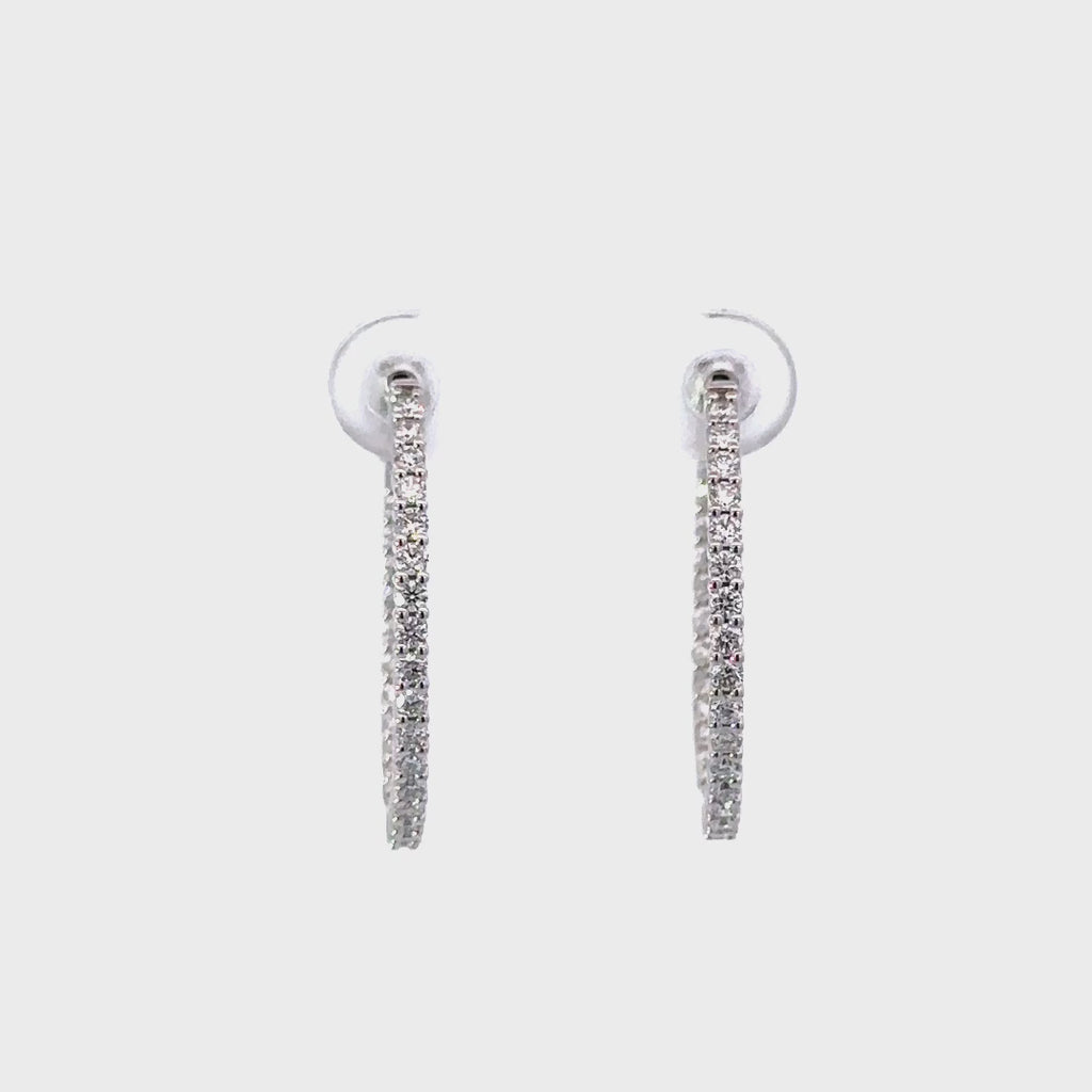 Silver diamond hoop earrings in a white background