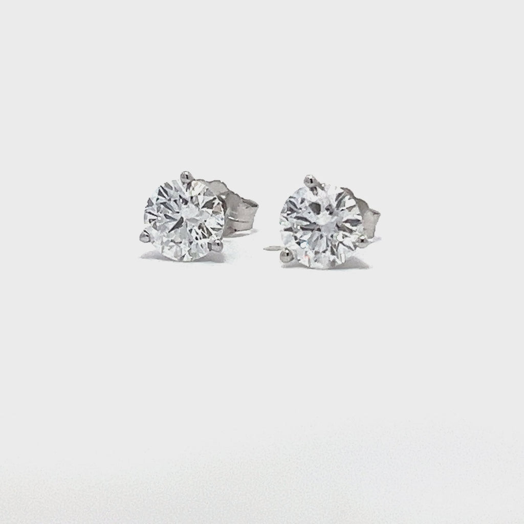 White gold stud earrings with round diamonds on a white background.