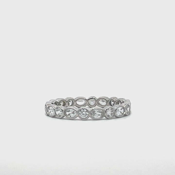 Silver eternity ring with oval stones on a white background