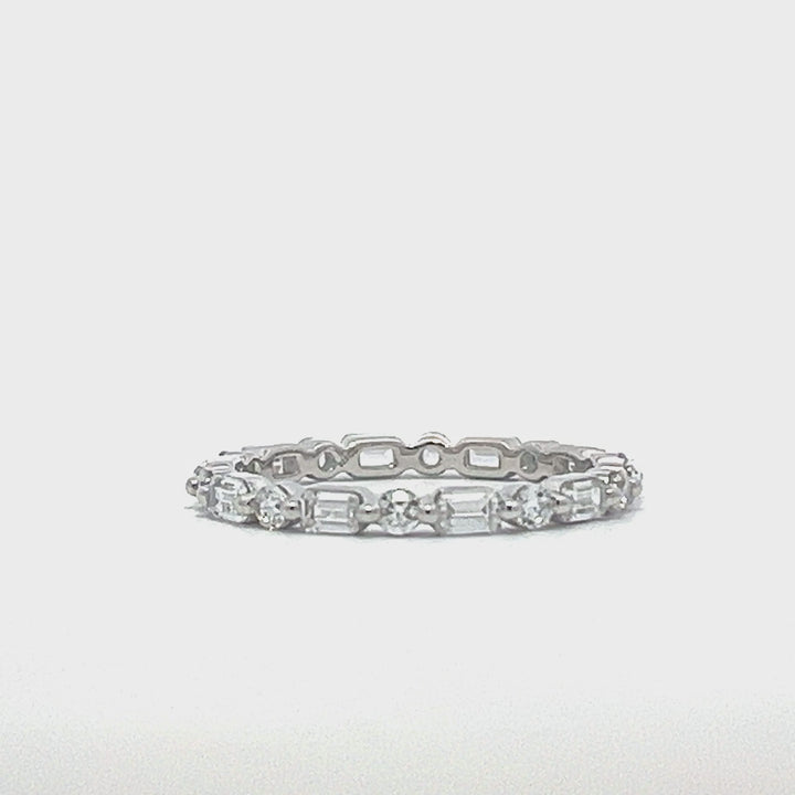 Silver eternity ring with round and baguette stones on a white background