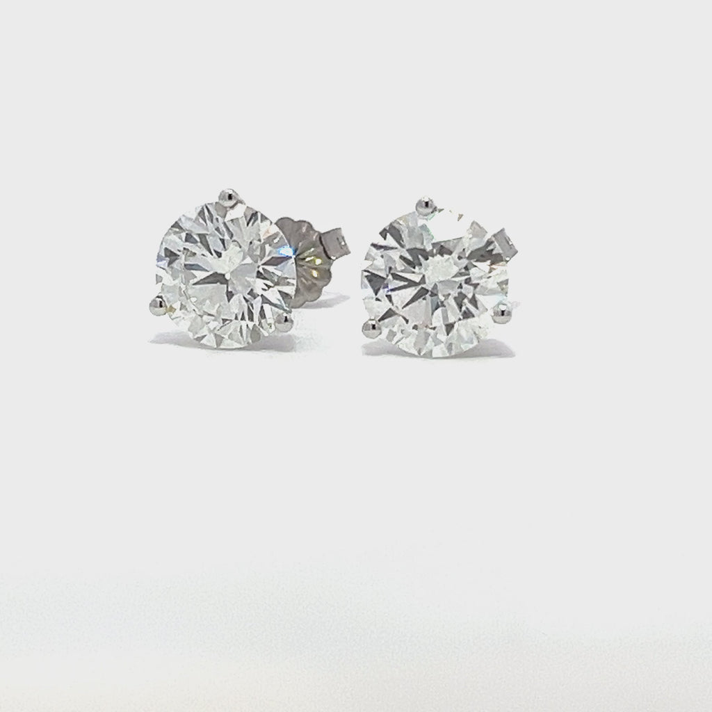 White gold stud earrings with round diamonds on a white background.