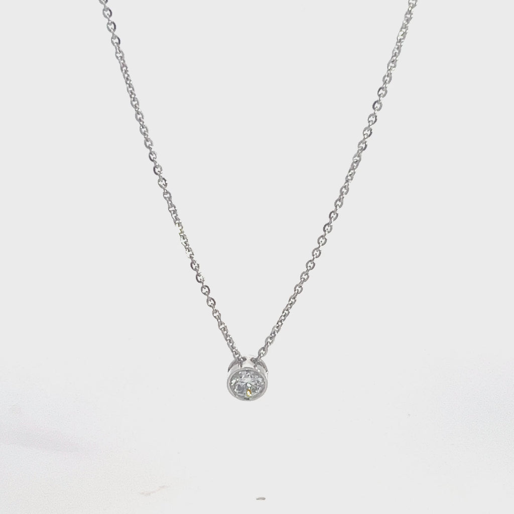 Silver necklace with a round diamond solitaire pendant on a white background.