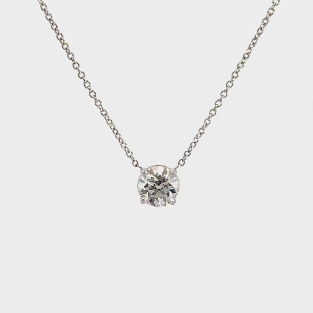 Diamond solitaire necklace on a white background.