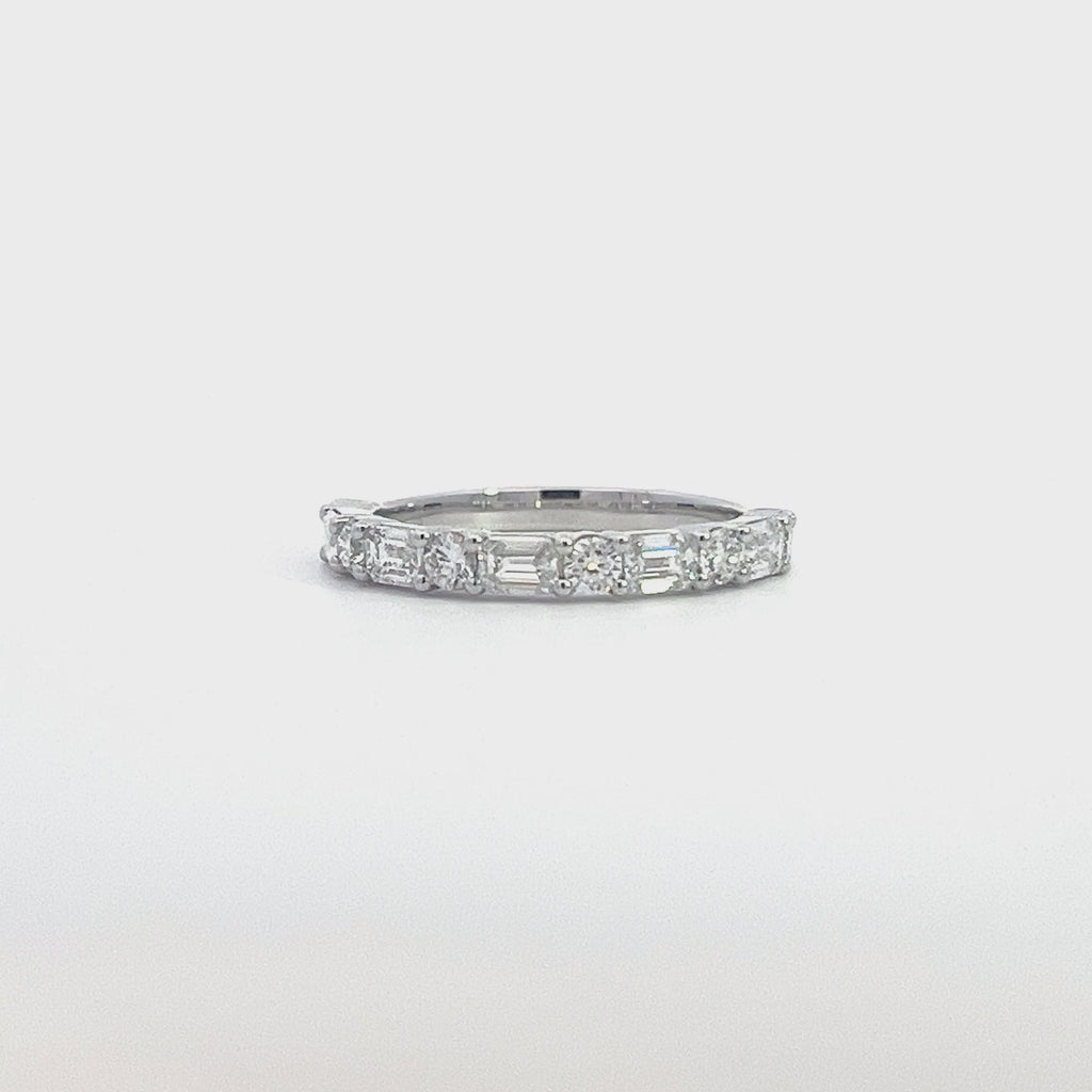 SIlver eternity band with alternating round and baguette-cut diamonds, on a white background.