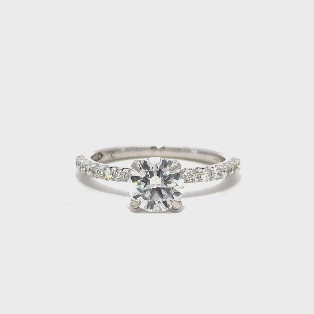 Silver engagement ring with a round-cut center diamond.