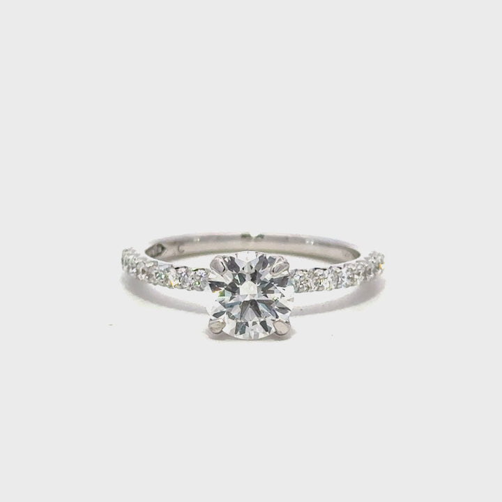 Silver engagement ring with a round-cut center diamond.