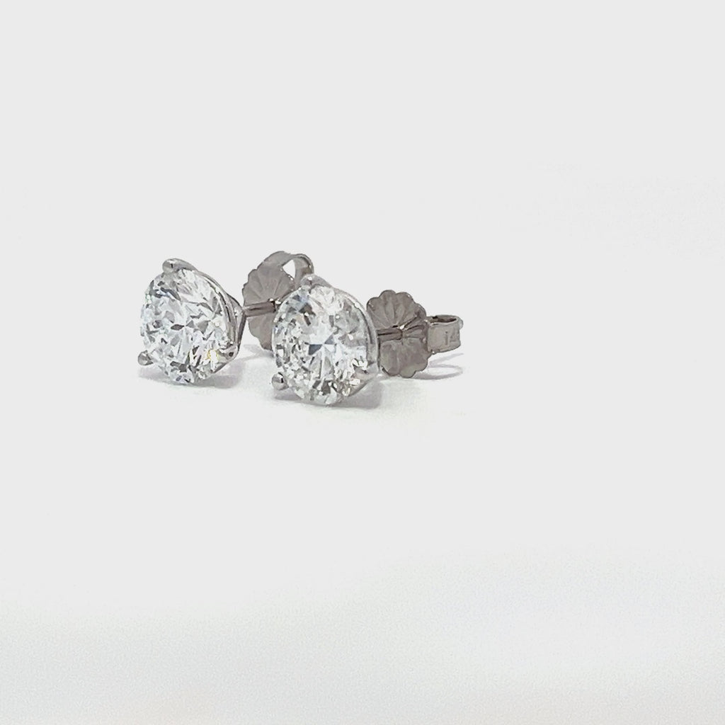 White gold stud earrings with round diamonds on a white background.