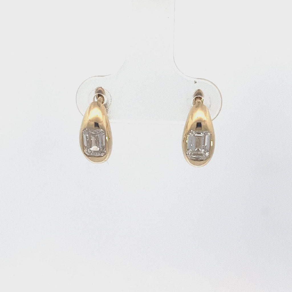 Yellow gold drop earrings with emerald-cut diamonds in an oval setting, on a white background.