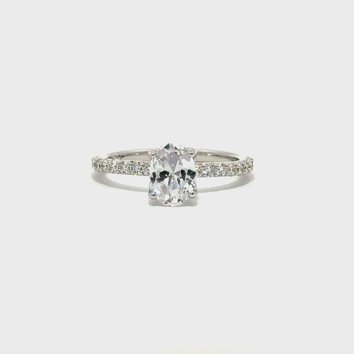 Silver engagement ring with a round-cut center diamond.