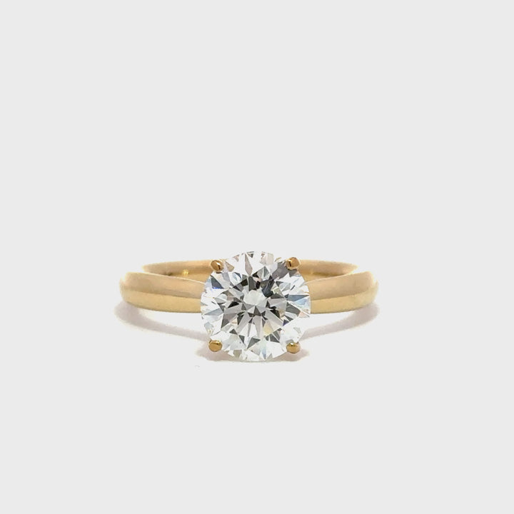 Gold engagement ring with a round-cut center diamond.