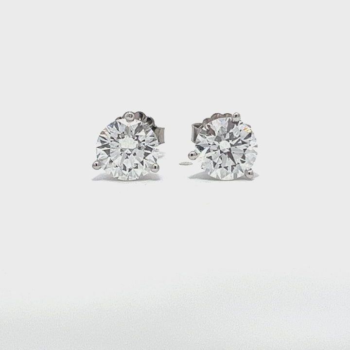 White gold stud earrings with round diamonds on a white background.