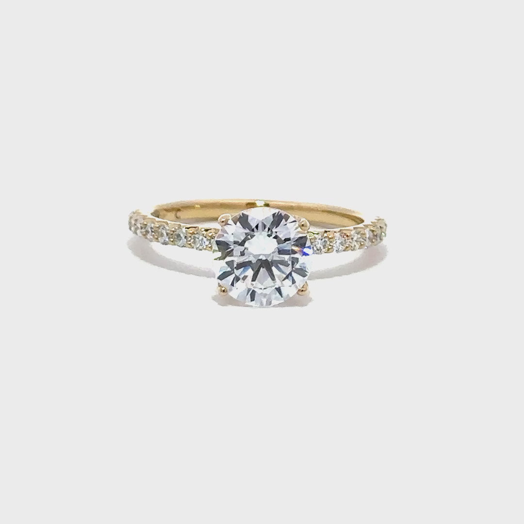 Gold engagement ring with a round-cut center diamond.