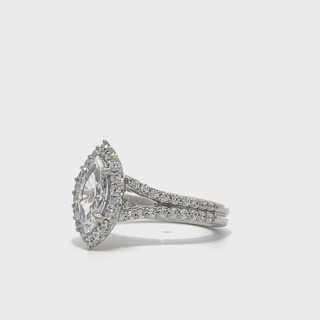 Silver pear-shaped diamond engagement ring with a halo setting and split shank on a white background.