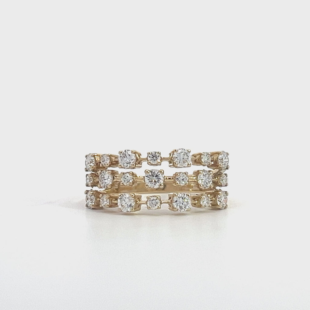 Yellow gold ring with three rows of diamonds, on a white background.