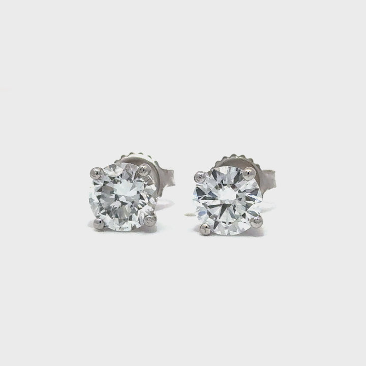 Pair of silver diamond earrings against white background