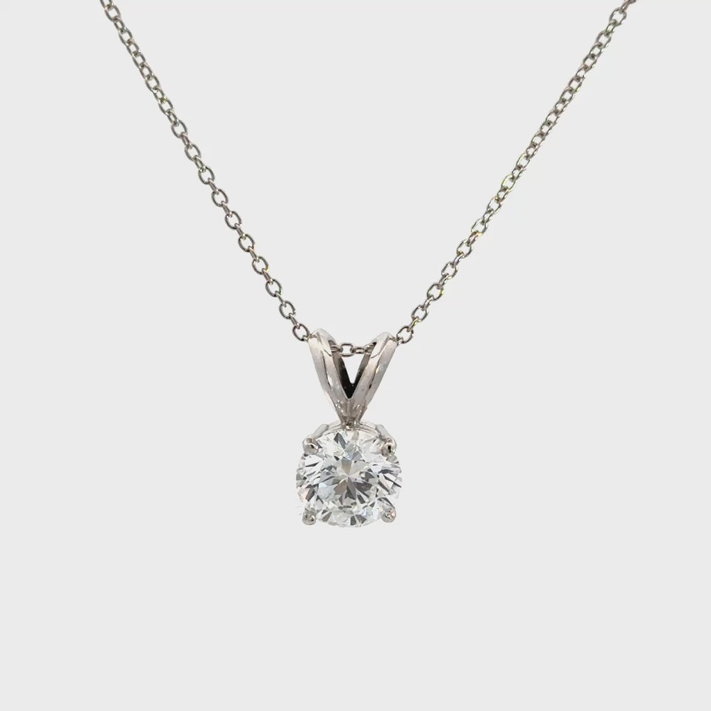 Silver necklace with diamond pendant against white background