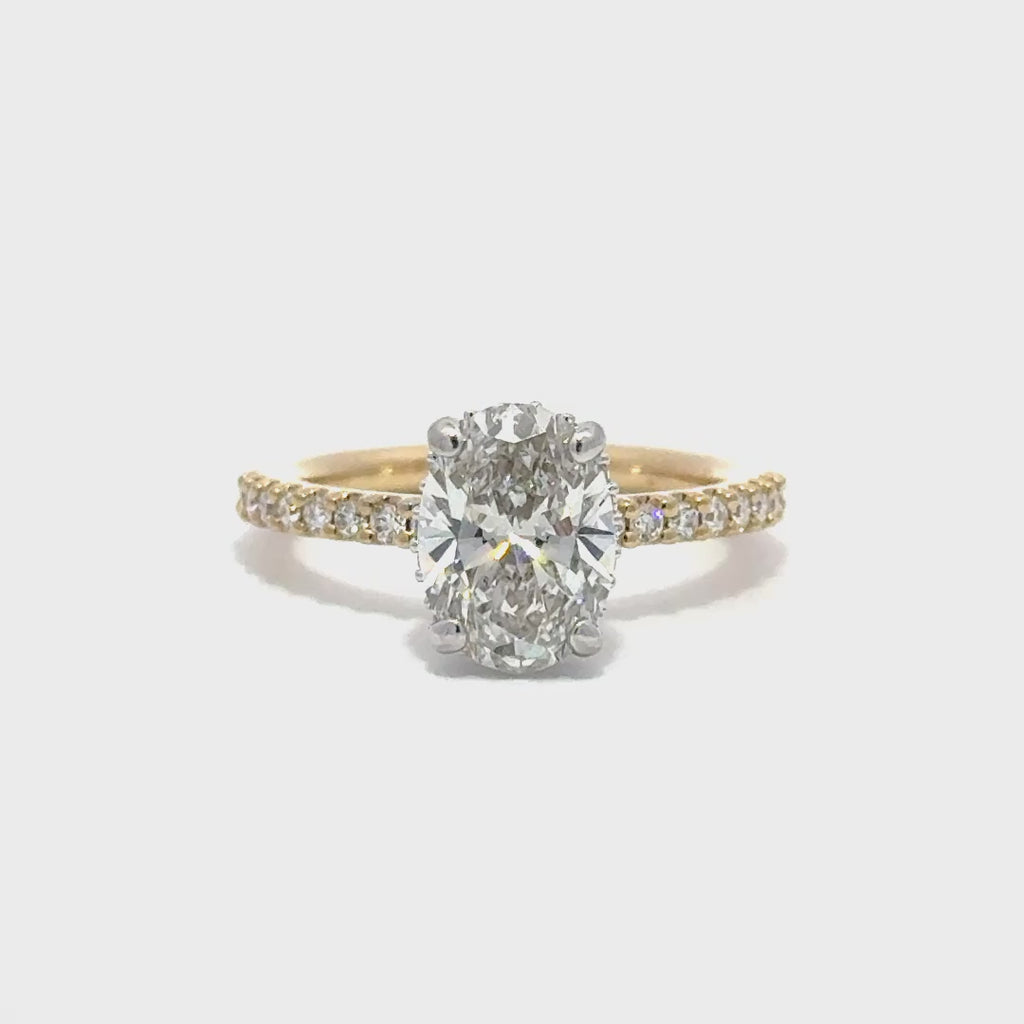 Multi color yellow and white gold engagement ring with a center oval cut diamond.