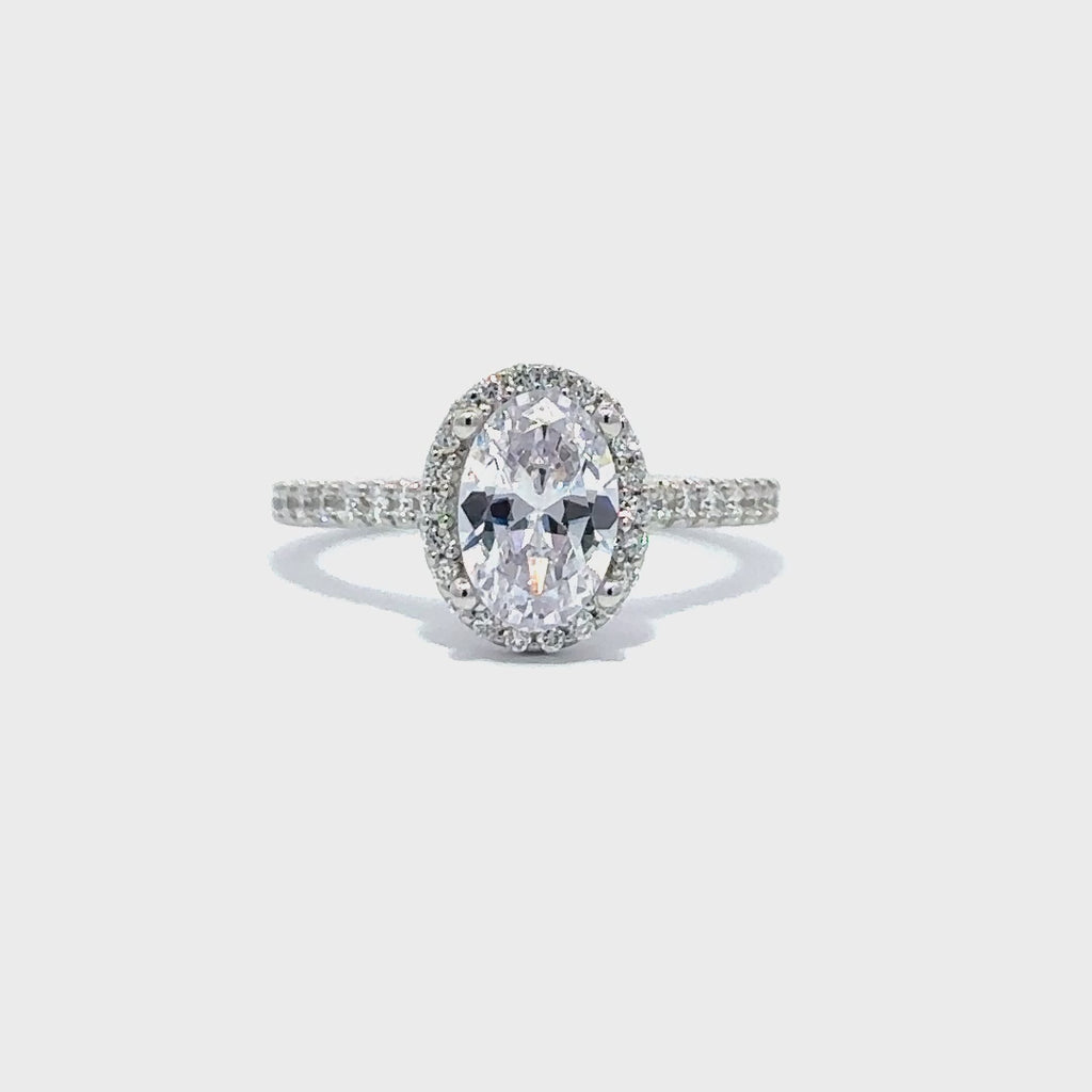 Silver engagement ring with a round-cut center diamond.