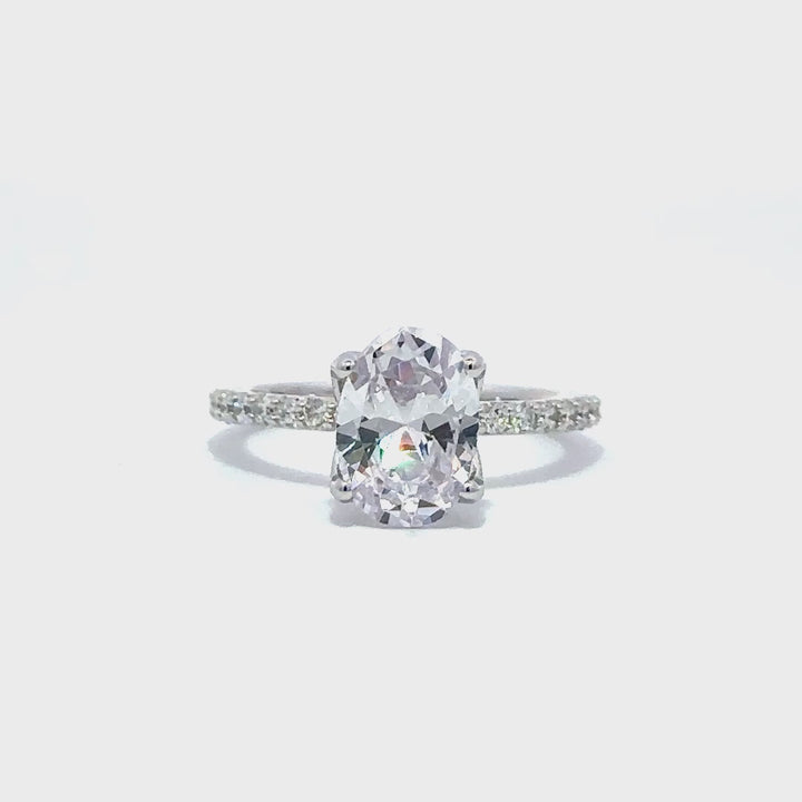 Silver engagement ring with a round-cut center diamond.