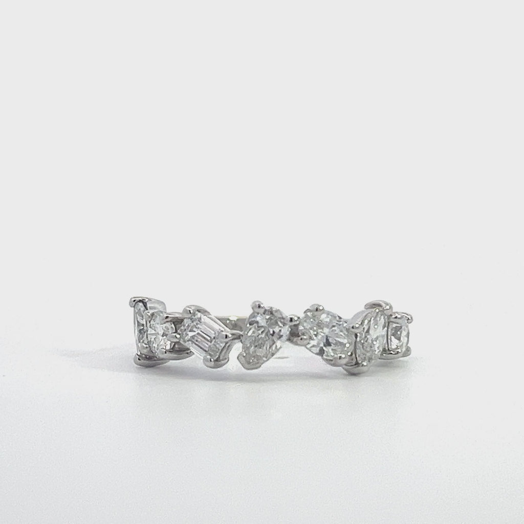 SIlver ring with a row of mixed-cut diamonds, including round, pear, and emerald cuts, on a white background.