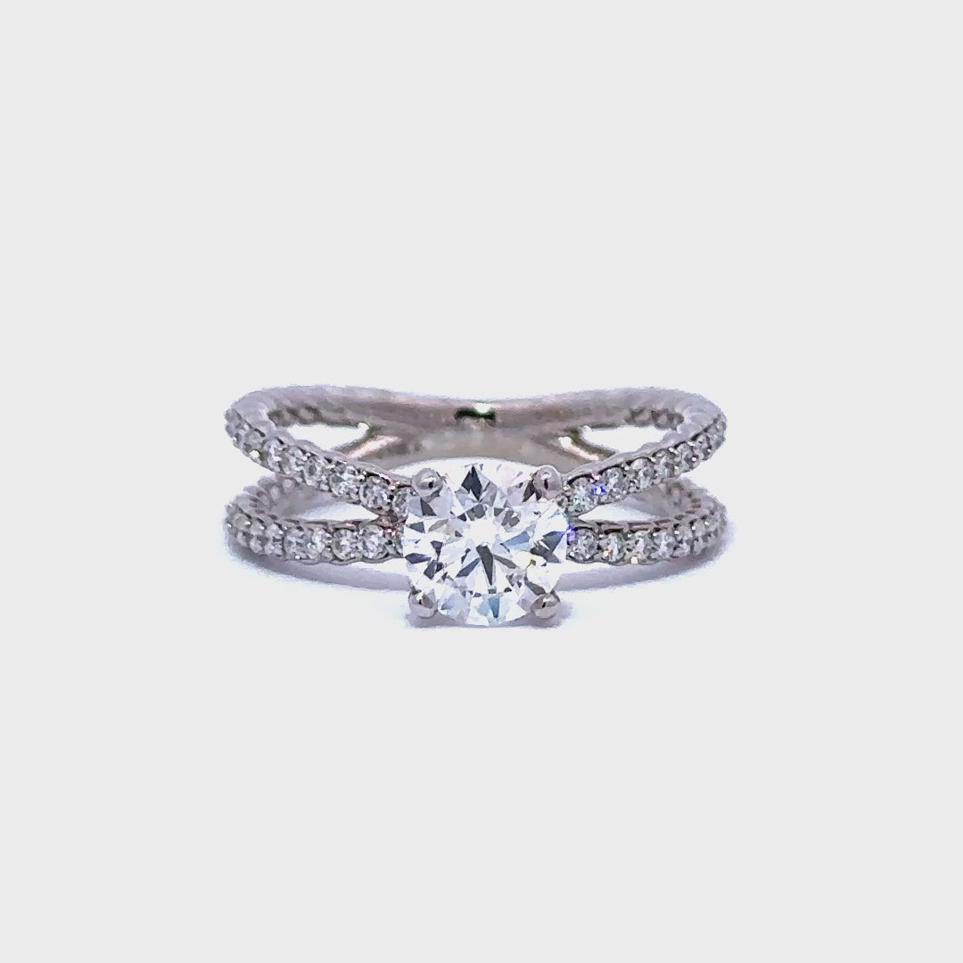 Silver engagement  ring with a round-cut diamond center stone and two split diamond bands, on a white background.