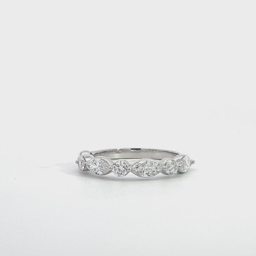 Silver eternity band with alternating round and marquise-shaped diamonds, on a white background.