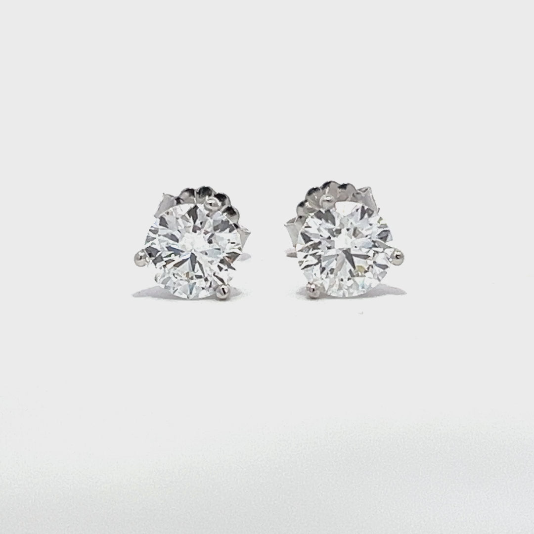 White gold stud earrings with round diamonds on a white background.