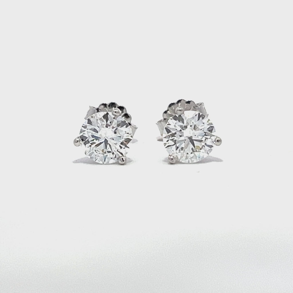 White gold stud earrings with round diamonds on a white background.