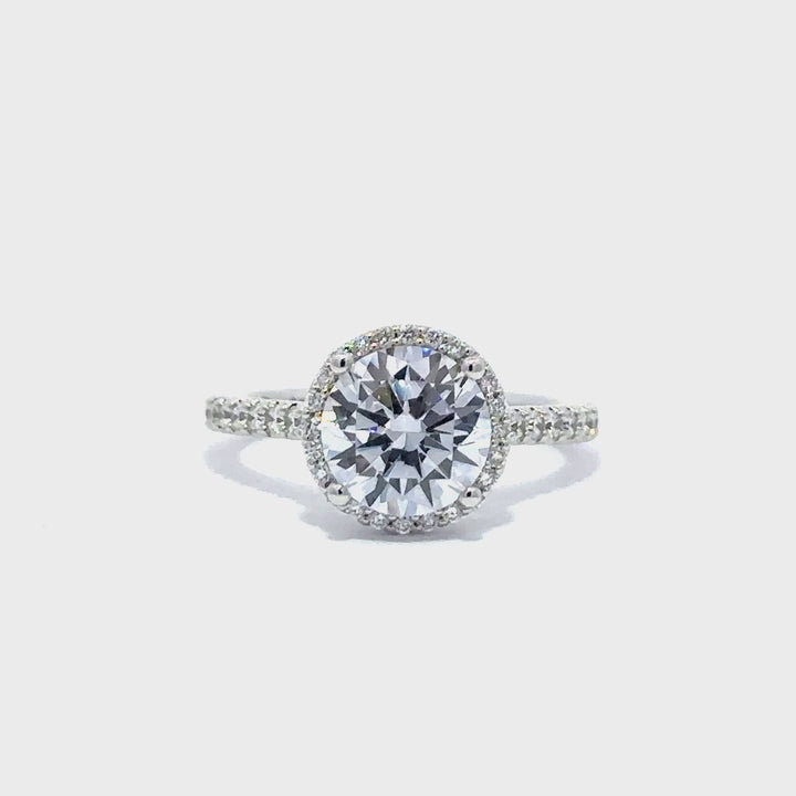 Silver engagement ring with a round-cut center diamond.