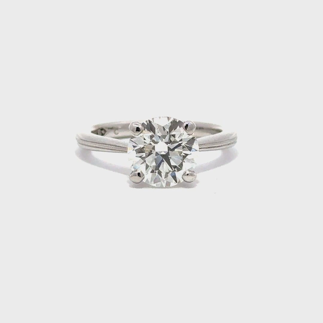 Silver engagement ring with a round-cut center diamond.